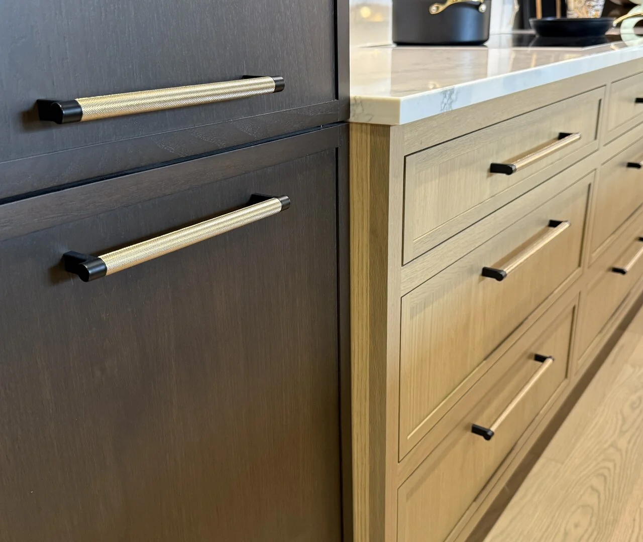 Knurled brass cabinet pulls on dark-stained and natural oak cabinetry